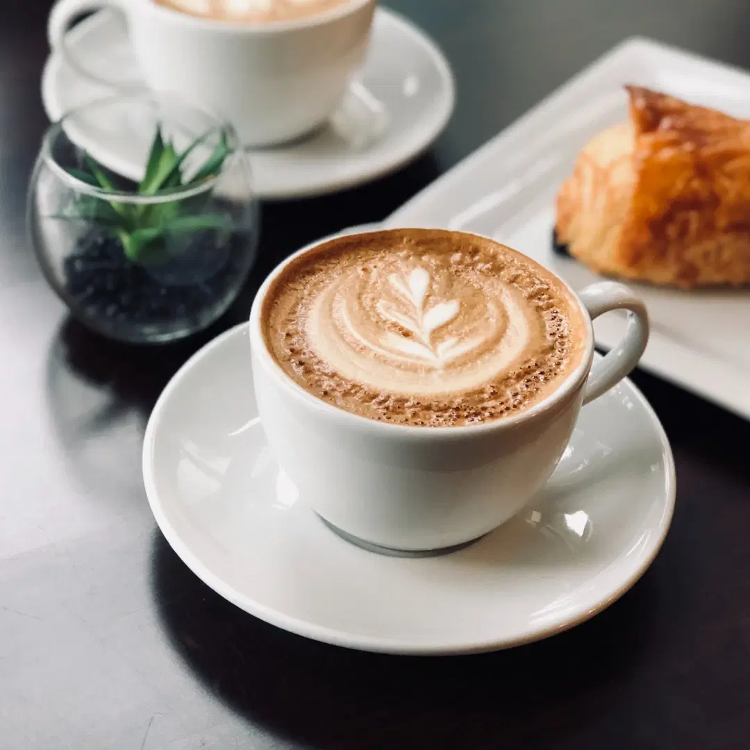 Latte with rosetta latte art in a white ceramic cup